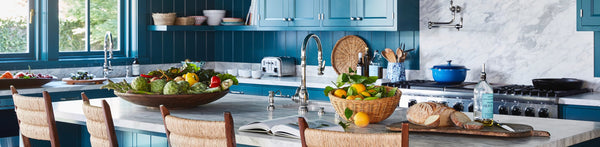 A close up of three counter stools with square backs made from rush and striped cushions, in a kitchen scene.