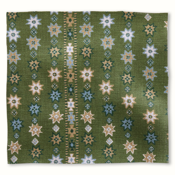 Green pillow featuring repeating star and geometric pattern in white, beige, and blue