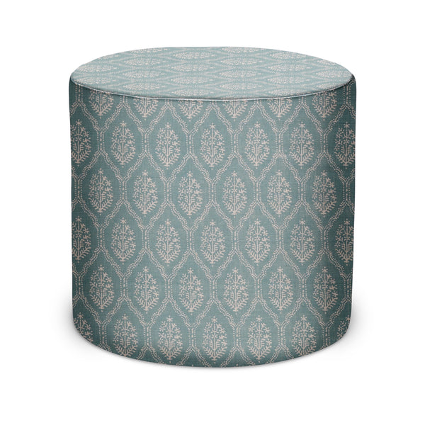 Indoor pouf in light blue jaali pattern fabric, round upholstered cylinder with flat top.