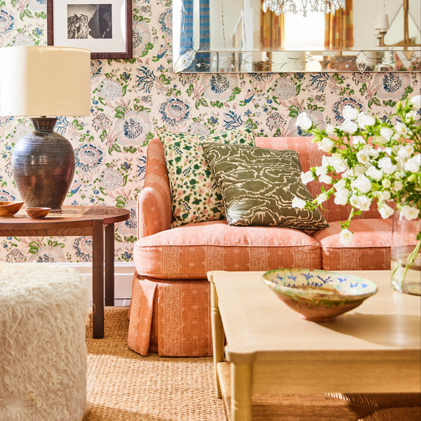 Sofa with upholstered arms and seat in orange fabric, styled with decorative pillows.