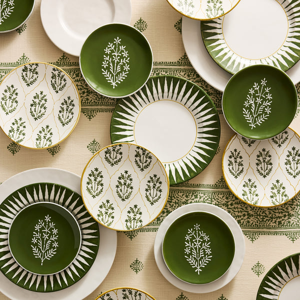 Assorted salad plates in olive green and white with botanical sprigs and sunburst rims