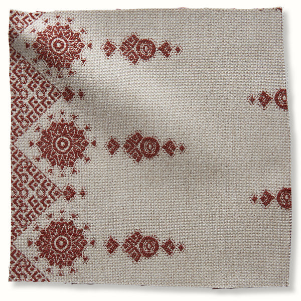 Outdoor red geometric medallion print pillow on natural woven fabric