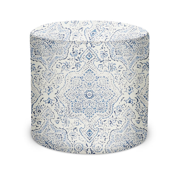Indoor pouf ottoman, cylindrical with blue-and-navy pattern on light upholstery