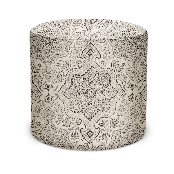 Indoor fabric pouf with charcoal patterned design on tan, rounded cylinder shape