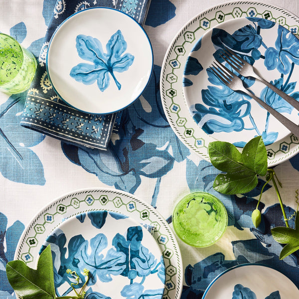 Hand-painted blue fig blossom appetizer plate, surrounded by matching plates and flatware