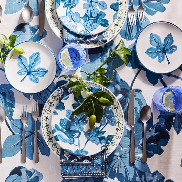 Hand-painted blue fig blossom appetizer plate with botanical motif, on table setting