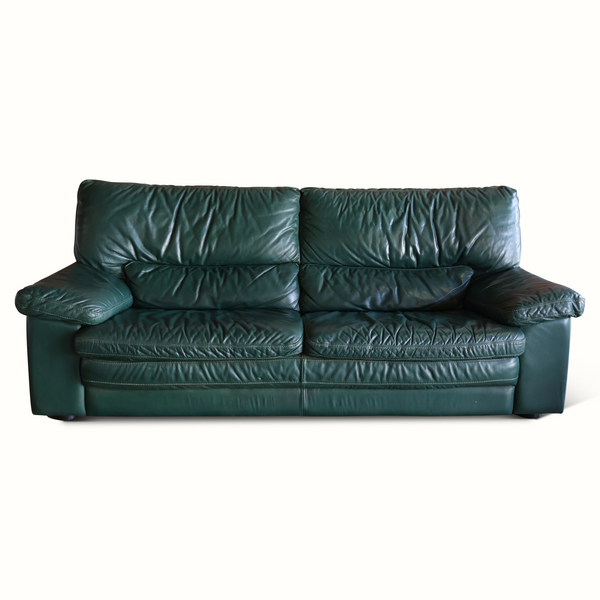 Dark green leather sofa with tufted back cushions and padded armrests