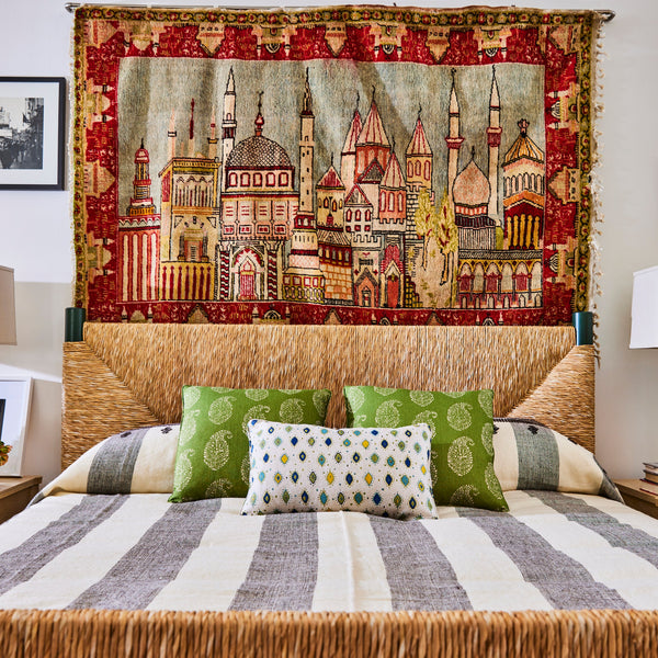 Perriand Rush Bed with light rush headboard and bench base, with patterned pillows