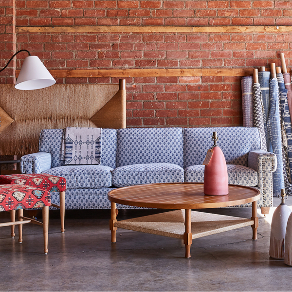 Light blue upholstered sofa with patterned throw pillows and low arm cushions