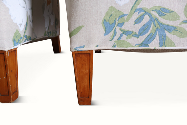 Wood armchair legs with floral upholstery, light gray base fabric and blue-green leaf pattern