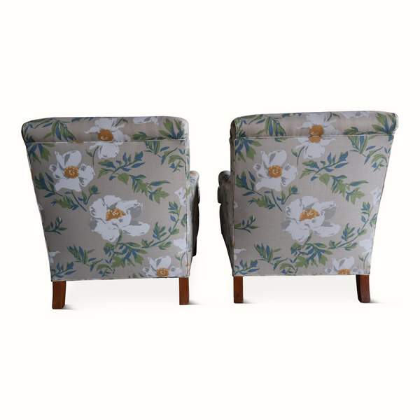 Set of two floral wingback armchairs, light gray fabric pattern with green leaves and orange blooms