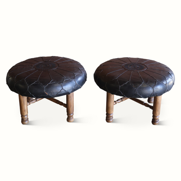 Pair of round ottomans showing side profiles, dark brown tufted seats and turned legs