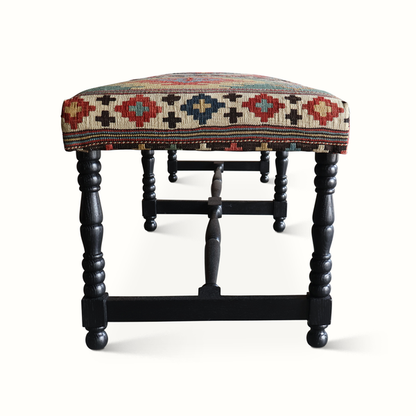Kilim bench underside view with multicolor patterned fabric seat on dark frame