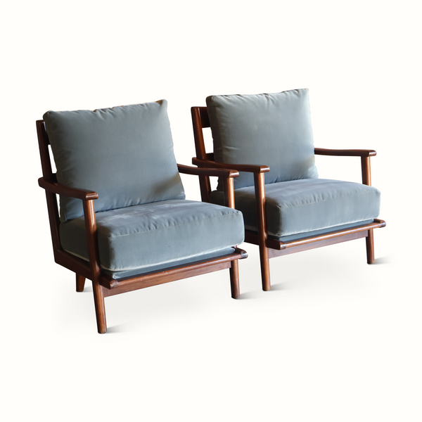 Pair of wooden armchairs with light blue cushions and padded armrests