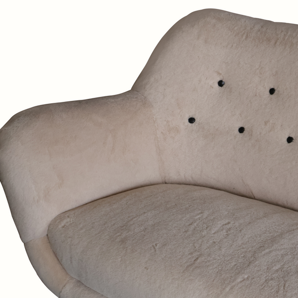 Close-up of button-tufted backrest and textured light gray upholstery on sofa.