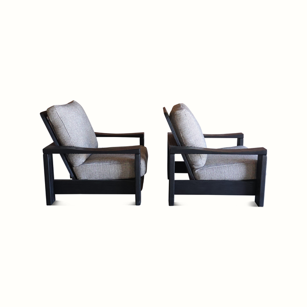 Pair of elm armchairs shown from the side with striped light blue linen cushions