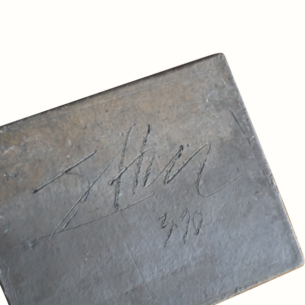 Close-up of ceramic block sculpture with engraved signature and numbers