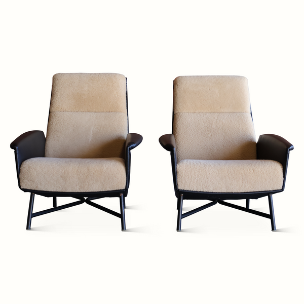Pair of lounge chairs with tall beige sheepskin backs and dark leather sides, black metal legs