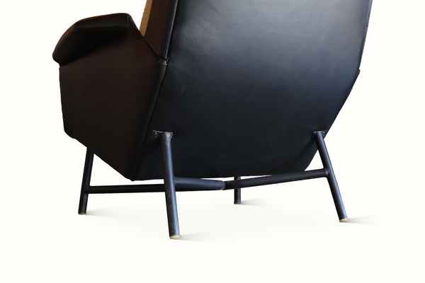 Dark leather lounge chair with curved armrests and metal legs, three-quarter side view