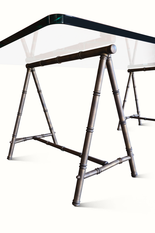 Coffee table base detail with curved bamboo-style legs supporting a clear glass top
