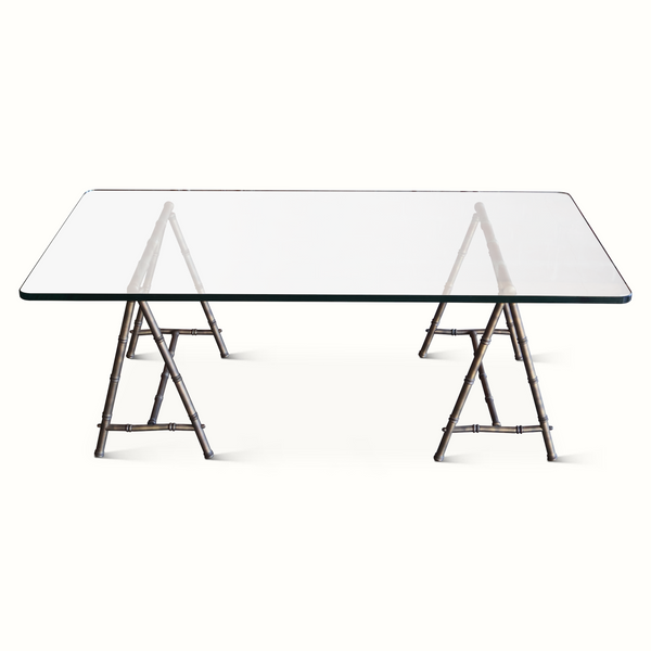 Coffee table with rectangular clear glass top and bamboo-style trestle legs