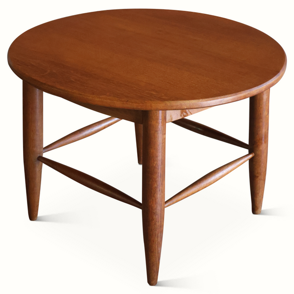 Dark brown round wooden side table with X-shaped apron and centered thick pedestal leg