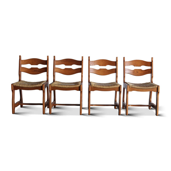 Set of four wooden dining chairs with wavy open backrest, armrests, and cushioned seats