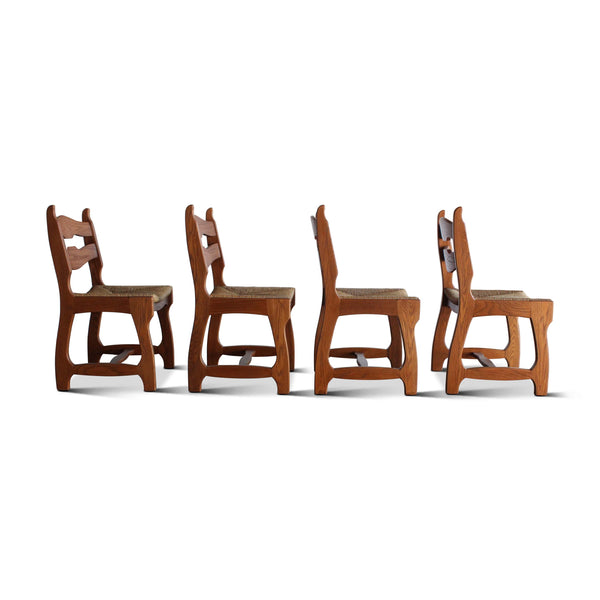 Set of four wooden dining chairs from a different angle, wavy backrest and upholstered seat cushions