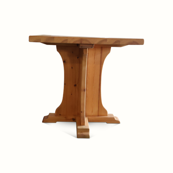 Pine bistro table with rounded pedestal base and wide square tabletop, light brown finish.