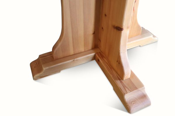 Pine bistro table base close-up with pedestal legs and wide foot crossbar, light wood.
