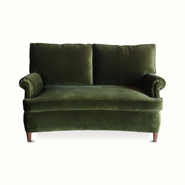 Green velvet French-style sofa front view with two-seat base, tufted back, rolled arms