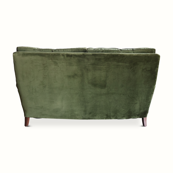 Green velvet French-style sofa back view with smooth back panel and wooden feet