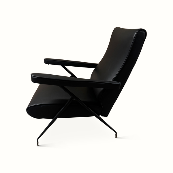 Black leather reclining armchair side view, padded seat and backrest with metal cross frame