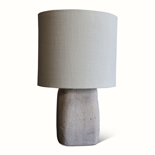 Table lamp with light fabric drum shade and speckled stone base, front view