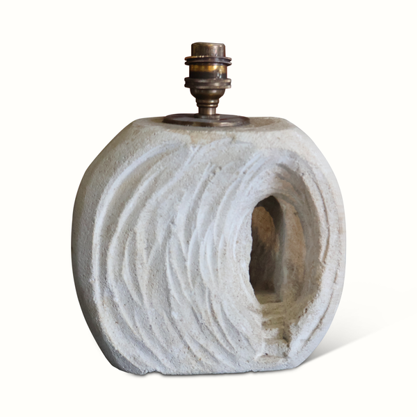 Table lamp with drum fabric shade and rolled stone base with visible lamp socket