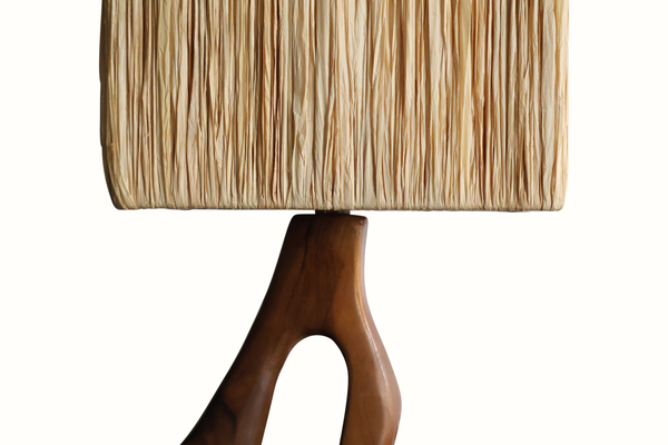 Olive wood table lamp close-up of beige pleated shade over warm-brown stem base
