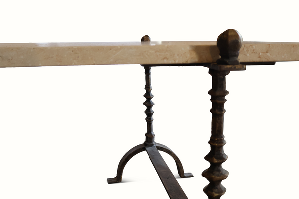 Limestone-topped table with two dark wrought iron legs and round finial brackets