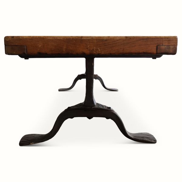 Coffee table with round pedestal base in forged iron and rustic oak tabletop.