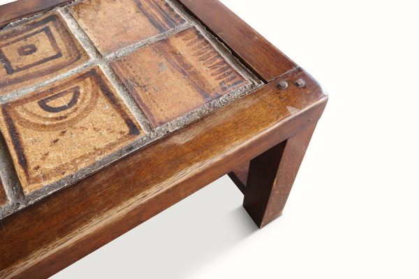 Wood bench corner with patterned ceramic tile inset on tabletop