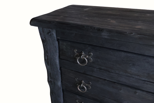 Corner close-up of ebonized oak chest top and drawer with ornate metal knob, dark finish
