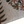 Beige ottoman cover detail with textured fabric, branch pattern, and dark wood side panel