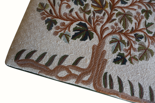 Beige ottoman top cover close-up with detailed tree trunk, leaves, and brown decorative border