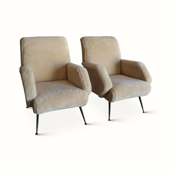 Pair of sheepskin armchairs with cream upholstery, rounded arms, and black tapered legs