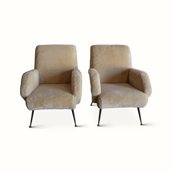 Pair of sheepskin armchairs facing forward, cream wool-look seats, rounded backs, black legs