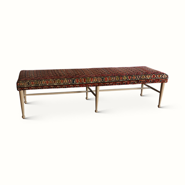 Patterned bench with red and navy rug top, detailed border, light wood legs