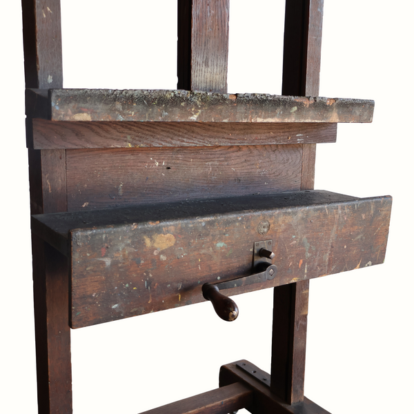 Antique wooden easel with worn paint, hinged panel, and built-in drawer front