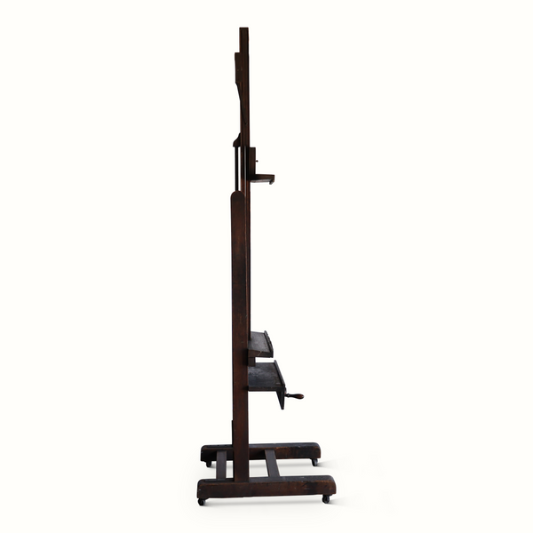 Antique wooden easel with upright frame, small ledge, and rolling base