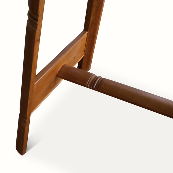 Oak flip-top game table corner detail with sturdy leg and horizontal support rail.