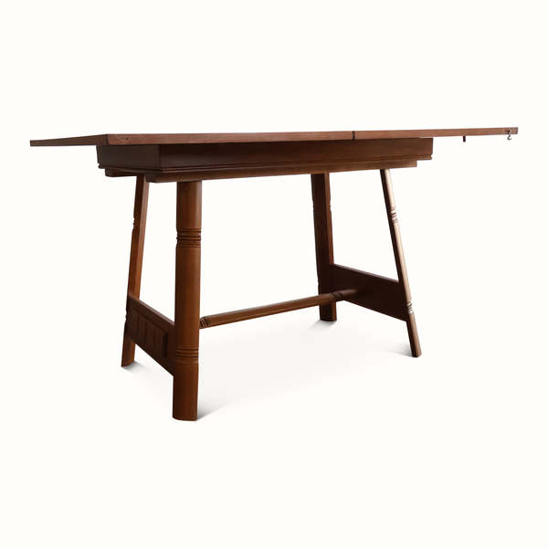 Oak flip-top game table angled view with extended top panel and lower support bar.