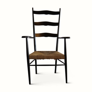 Rush armchair with black wood frame, wavy back slats, and woven brown seat cushion